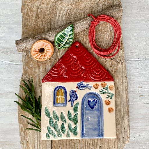 Négy cseréptetős házikó, a négy évszak színeiben pompázó kerttel és kék madárkákkal
