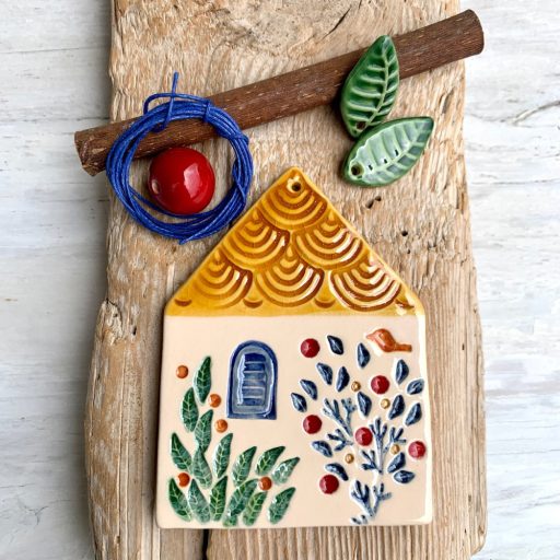 Négy cseréptetős házikó, a négy évszak színeiben pompázó kerttel és kék madárkákkal