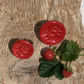 Piros, kerek gyűrű, kisebb-nagyobb méretben, csillagvirág és levél mintával, kézzel készült kerámia ékszer.